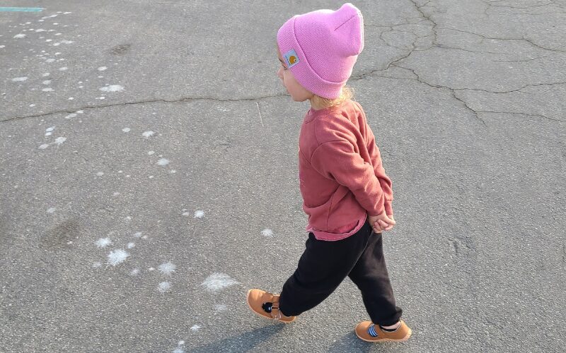 kid walking with pink hat