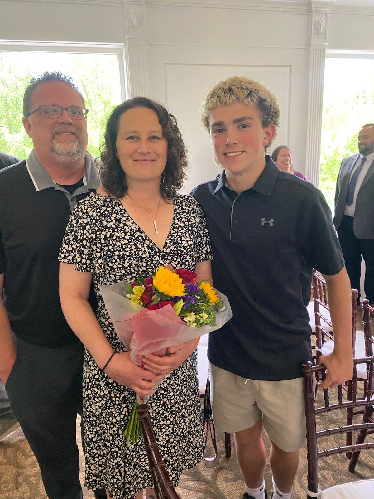 A woman with her family holding a bouquet of flowers