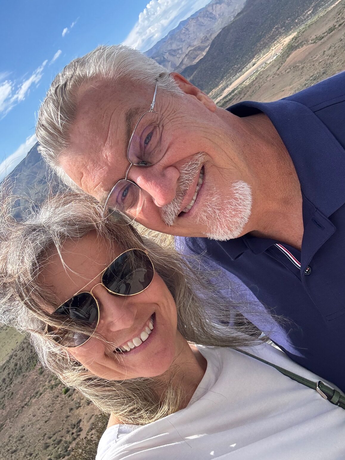 Couple smiling outdoors with mountain landscape — Meridian Financial Partners client story